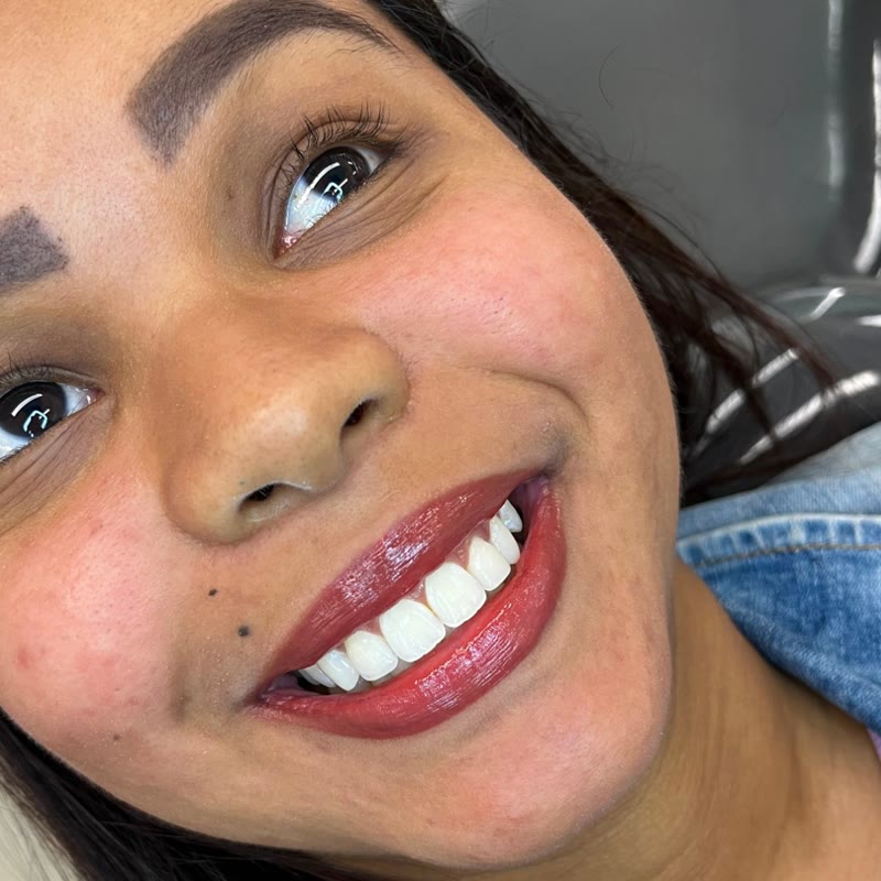 Paciente sorrindo após tratamento na clínica